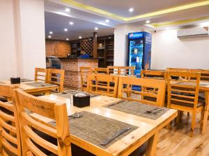 加德满都Kathmandu Aagantuk Hotel的用餐室配有木桌和椅子
