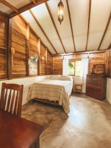 MéridaCasa Papaki的卧室配有一张床铺,位于带木墙的房间内