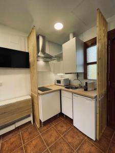 SelorioApartamento familiar cercano a playa de Rodiles 1的小厨房配有白色橱柜和水槽