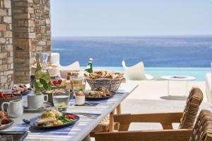 迈洛波塔斯Ios Grand Pool Suites的一张桌子,上面有食物,享有海景