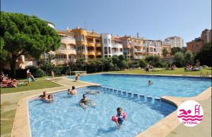艾姆布里亚布拉瓦Appartement 1 chambre climatisé avec 3 piscines à 200 m de la plage的一群人在游泳池游泳
