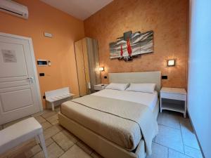 马利耶Mediterraneo B&B的一间卧室设有床和两张桌子,还有一扇门