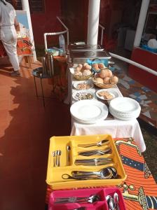 Santo AntónioResidencial Brigada的桌子上摆着盘子和餐具,上面摆着食物