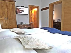 普利特维采村Green Garden Plitvice lakes的一间卧室配有2张白色的床和平面电视