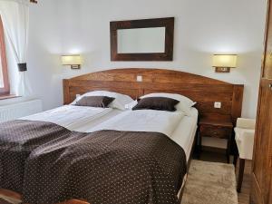 普利特维采村Green Garden Plitvice lakes的一间卧室配有一张大床和木制床头板