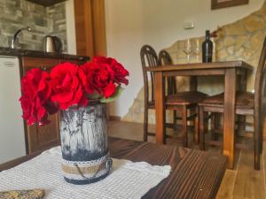 普利特维采村Green Garden Plitvice lakes的一张桌子上满是红玫瑰的花瓶