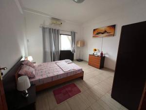 罗安达África em Zona Comercial de Luanda的一间卧室设有一张大床和一个窗户。