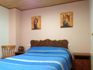 拉普埃夫拉德瓦尔韦尔德奥提纳公寓的卧室配有一张床,墙上有三幅照片