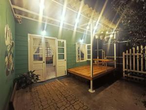 大叻MOre Home - Ngôi nhà nghĩ dưỡng tại Đà Lạt的绿色的客房设有木桌和门