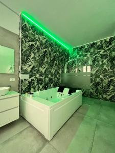 米兰CA.FOSCARI HARMONY的一间带大浴缸和绿灯的浴室