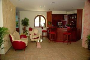 贝尔韦代雷Agriturismo L'Arca di Anna Brambilla的一间带红色和白色椅子的客厅和一间厨房
