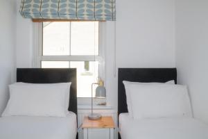 巴斯Sydney Wharf House的一间卧室设有两张床和窗户。
