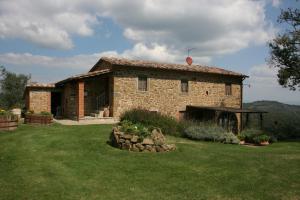 齐奇亚诺Podere della Crocchia的一座带草地庭院的小石头房子