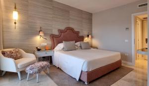 切尔沃港CPH | Pevero Hotel的一间卧室配有一张大床和一把椅子