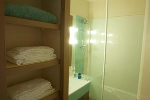 圣马洛皮埃尔瓦肯斯泰垫酒店的带淋浴、水槽和毛巾的浴室