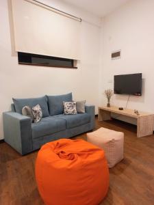 库鲁内格勒NINETY-NINE APARTMENTS的客厅配有蓝色的沙发和平面电视。