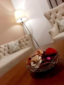 库鲁内格勒NINETY-NINE APARTMENTS的客厅配有沙发和一碗鲜花在桌子上