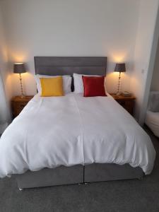 赫尔斯顿Bosloe的卧室配有带4个枕头的白色床