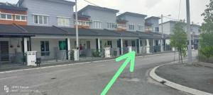 斯里伊斯兰德Raihan Homestay Seri Iskandar Perak Near UTP UITM的房屋前的一条路上的绿箭