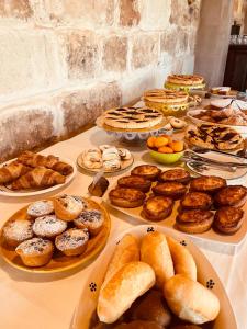 切萨雷奥港Masseria Casina Bellanova的一张桌子,上面摆放着各种糕点和馅饼