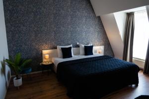 迪尔斯泰德附近韦克Hotel Brasserie Florian的一间卧室设有一张床和蓝色的墙壁