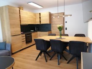 玛丽亚阿尔姆Das Prinzenberg Appartement的厨房以及带木桌和椅子的用餐室。