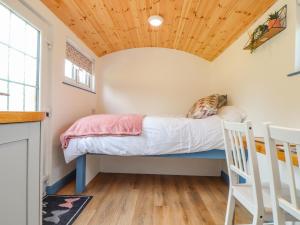雷德鲁斯Rose的小屋内的一张床位,设有木制天花板