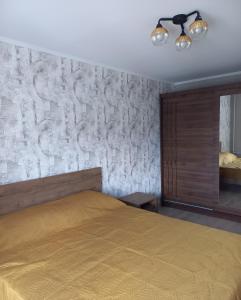 陶格夫匹尔斯Kandavas Street City Center Apartment的一间卧室设有一张床和石墙