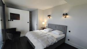 勒·雷约尔·卡纳德尔·苏尔Villa Gabiano的一间卧室配有一张带白色床单和椅子的床