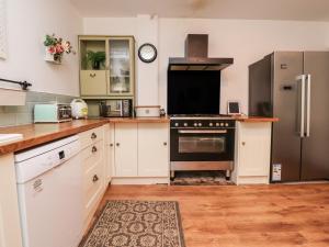 莫克姆112 Balmoral Road的厨房配有白色橱柜和黑烤箱。