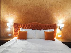 锡比乌Boutique Central的一间卧室配有一张带橙色枕头的大床