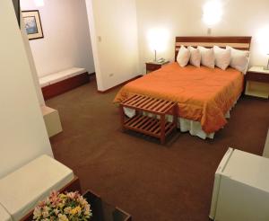 阿雷基帕Hotel San Andres的酒店客房,配有带橙色床罩的床