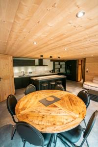 沙泰勒CHALET LES CERFS的厨房里配有一张木桌和椅子