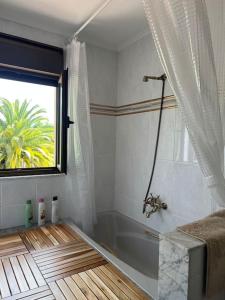 奥维多La Casona de la Carbayeda的带浴缸的浴室和窗户。