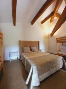 Le BoscEscale au Salagou的一间带一张大床的卧室,位于一个拥有木制天花板的房间