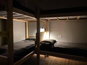 采西斯Boutique Hostel Cesis-X的配有两张双层床的黑暗客房,配有灯