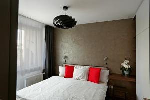 布拉迪斯拉发Modern apartment near the city centre URBAN的一间卧室配有红色和白色枕头的床