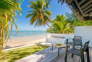 莫雷阿莫雷阿海滩酒店 的海滩上带2把椅子和1张桌子的甲板