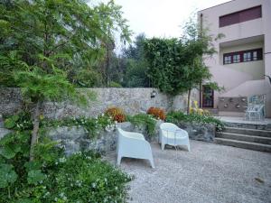 吉马良斯吉马良斯生活探险旅舍的庭院设有两把白色椅子和一堵墙