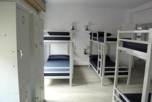锡列达Albergue Trabazo的一间客房配有4张双层床,铺有蓝色和白色
