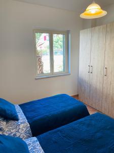 斯卡莱阿Marina Apartament的一间卧室设有两张蓝色的床和窗户