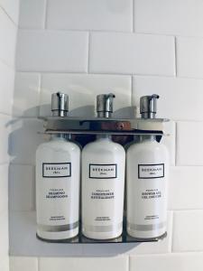 华盛顿HighRoad Washington DC的浴室的架子上放了三瓶肥皂