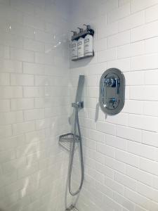 华盛顿HighRoad Washington DC的白色瓷砖浴室设有淋浴和开胃菜