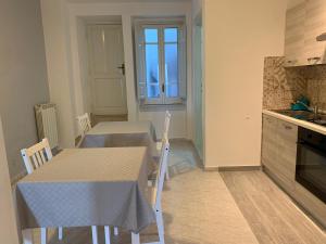 福尔米亚Il Nido delle Rondini的厨房配有2张桌子和1张桌子及椅子