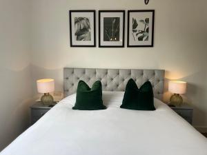 Eynsford城堡酒店的一张带两个绿色枕头和两盏灯的白色床