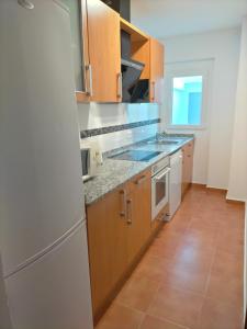萨拉曼卡Agradable casa con patio的厨房配有木制橱柜和白色冰箱。