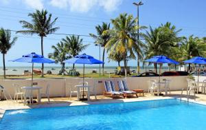 马拉戈日 马里卢斯包萨达旅馆的一个带椅子和遮阳伞的游泳池和海滩