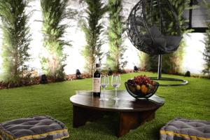 海若克利欧Damona 2BR Luxury Home with garden - κοντά στο κέντρο的一张桌子,上面放着两杯葡萄酒和一碗水果