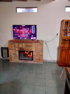 Las CompuertasLa Bohemia的一间带电视和壁炉的客厅
