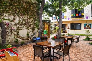 洛雷托Hotel Casa Mangos Loreto的户外庭院配有桌椅和树木。